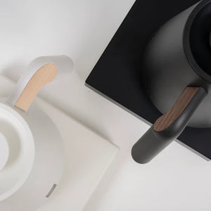 Detailfoto van een zwarte en witte elektrische waterkoker met houten details voor barista- en filterkoffie-accessoires van Timemore