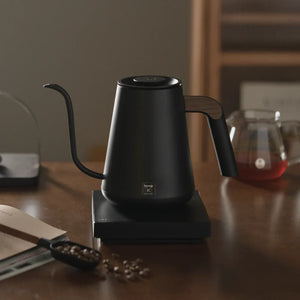 Zwarte elektrische waterkoker met smalle tuit en houten handvat voor barista- en filterkoffie-accessoires van Timemore, alles over koffie.