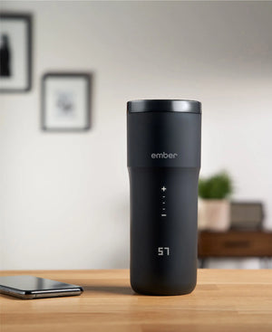 Electric Coffee Travel Mug black V2 - 355ml op tafel met digitale temperatuurweergave in moderne binnenomgeving.