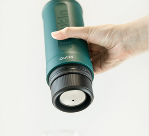 Draagbare koffiebrouwer in bosgroen met aangepaste capsulehouder, perfect voor handmatig brouwen buiten en koffieliefhebbers.