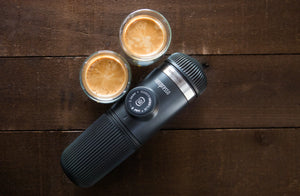 Draagbare espressomachine met twee kopjes espresso op een houten oppervlak, van draagbare koffiemachines en barista-uitrusting